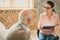 Woman in pink blouse having important conversation with old man