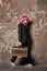 Woman in pink hair wig, headphones carry retro suitcase