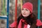 Woman in pink hat sitting on swing in winter