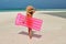 Woman with pink inflatable raft at the beach