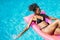 Woman on pink inflatable in swimming pool