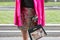 Woman with pink jacket and colorful sequin skirt and bag with horse design before Emporio