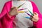 Woman with a pink knitted jacket holding colourful crochet needles in different sizes