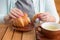 Woman with pink manicure is tearing a small piece from large croissant