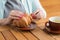 Woman with pink manicure is tearing a small piece from large croissant , aliened