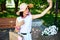 Woman in pink medical mask in the park take selfie by mobile phone