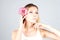 Woman with a pink orchid touching chin with proud look. Beauty blond woman.