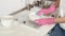 A woman in pink rubber gloves foam washes a plate in a large sink at home