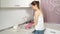 A woman in pink rubber gloves foam washes a plate in a large sink at home