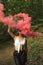 Woman with pink smoke bomb in the woods