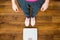 Woman with pink sneakers on bathroom weight scale