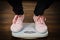 Woman with pink sneakers on bathroom weight scale
