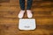 Woman with pink sneakers on bathroom weight scale