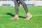 Woman with pink sneakers standing on football field with the white line. ready for running on the stadium