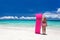 Woman with pink swimming mattress on tropical beach