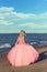 Woman in pink tulle dress walking on the beach