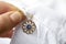 Woman pinning evil eye amulet on clothing, closeup