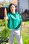 Woman with pitchfork and carrot at her garden