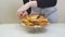 woman place cheeseburgers and french fries on a round glass dish. original cake