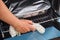 Woman placing a glass tray covered with foil that has chicken inside into an oven