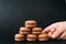 Woman placing macaroons on heap on black background