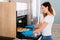 Woman Placing Tray Of Cookies In Oven