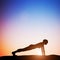 Woman in plank yoga pose meditating at sunset. Zen