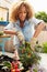 Woman Planting Container On Rooftop Garden