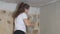 woman plasterer plasters the wall with brush, renovation work of an apartment, industrial construction contractor