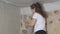 woman plasterer plasters the wall with brush, renovation work of an apartment, industrial construction contractor