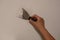 Woman plasterer repairing wall with putty. Close-up, copy space