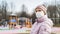 Woman at playground with surgical mask on face during COVID-19 coronavirus pandemic