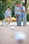 Woman playing boule with group of seniors