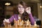 Woman playing chess indoor and thinking position, find winning move, strategy