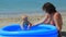 A woman is playing with a child in an inflatable pool