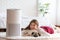 Woman playing with Dog Pug Breed and Air purifier in cozy white bed room for filter and cleaning removing dust PM2.5 HEPA in home