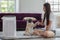 Woman playing with Dog Pug Breed and Air purifier in cozy white living room