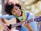 Woman playing guitar in park