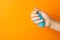 Woman playing with light blue slime on orange background, closeup. Antistress toy