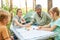 Woman playing ludo with man and children in forest