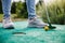 Woman playing mini golf and trying putting ball into hole