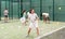 Woman playing padel. In the background, athletes are training