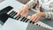 Woman playing piano record music on synthesizer using notes and laptop. Female hands musician pianist improves skills