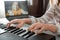 Woman playing piano during video call via laptop. Female hands musician pianist improves skills playing piano online classes with