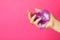 Woman playing with purple slime on pink background. Antistress toy