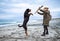 Woman playing with rottweiler dog in cold weather on the beach