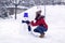Woman  playing with a snowman on winter day.Wintertime. Happy holiday