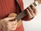 Woman playing soprano ukulele indoors