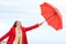 Woman playing with an umbrella in winter on the beach