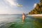 Woman plays frisbee in the water of beautiful ocean